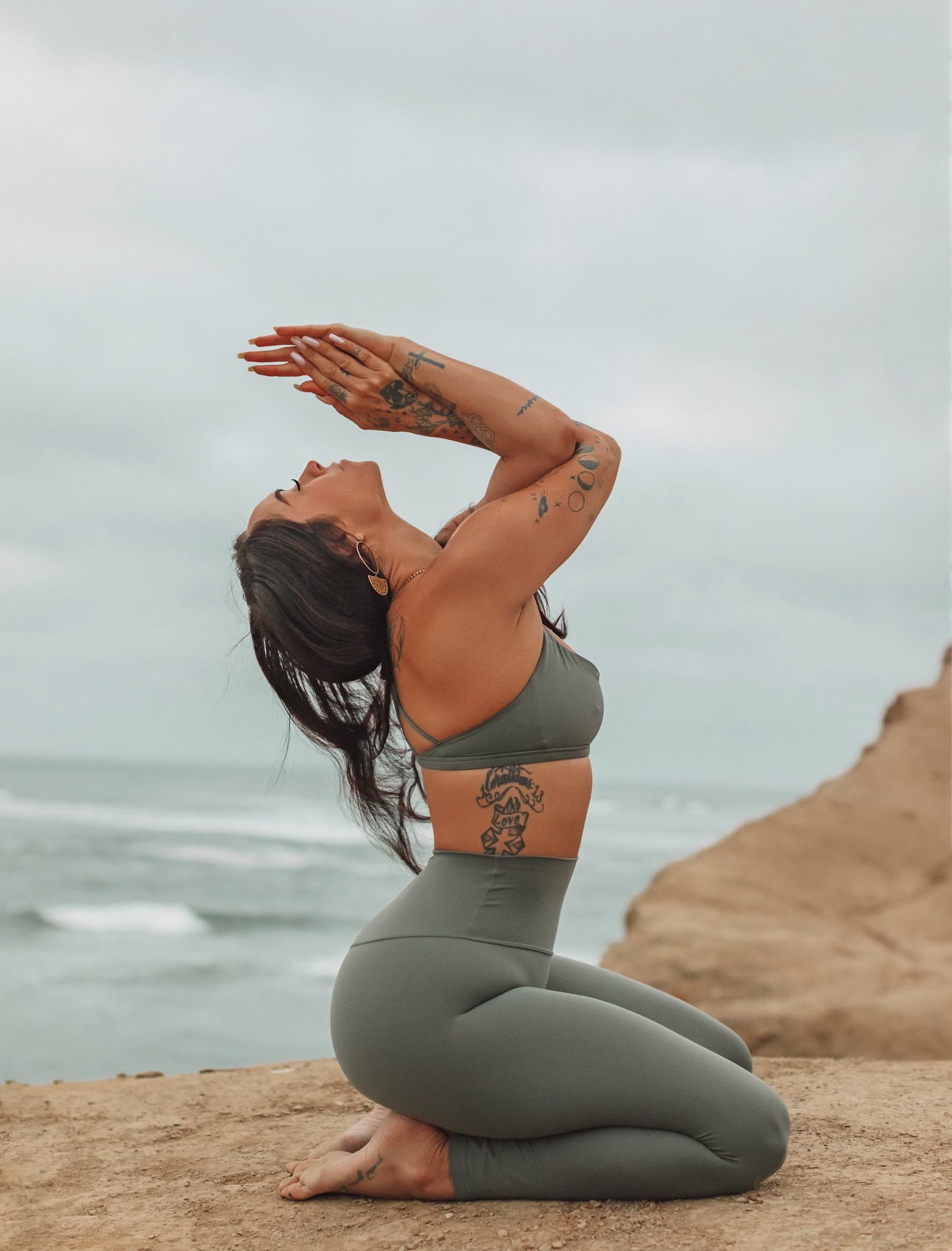 Kaitlyn practicing yoga beside the ocean